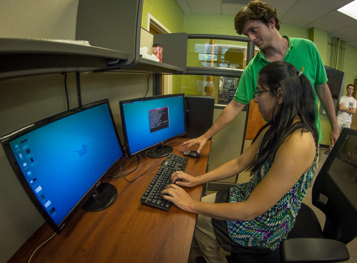 Staff assisting a student at a computer