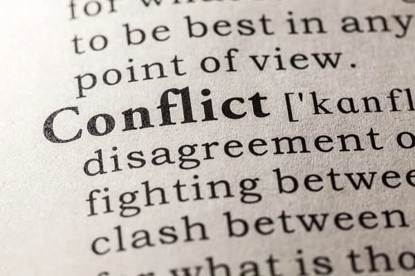 The image shows a close-up of a dictionary page featuring the word "Conflict" and its definition.